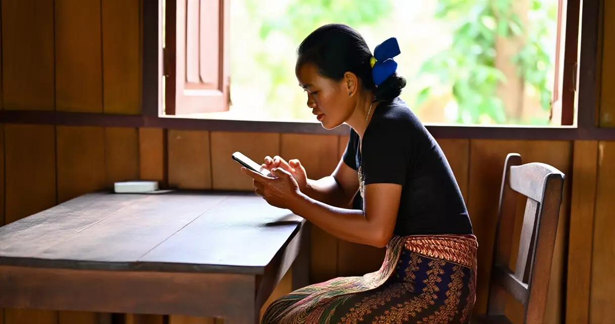 ស្ត្រីខ្មែរស្លៀកសំលៀកបំពាក់បុរាណកំពុងមើលទូរស័ព្ទ