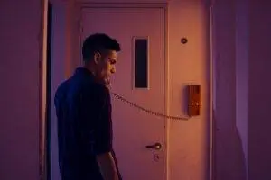Side view of a man in a blue shirt making a phone call indoors in Buenos Aires.
