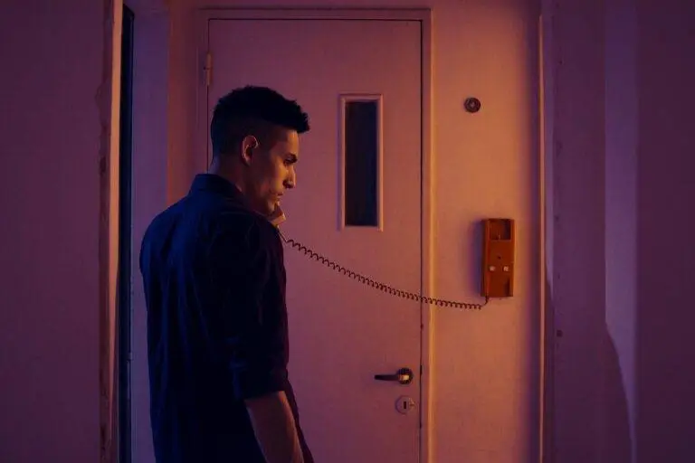 Side view of a man in a blue shirt making a phone call indoors in Buenos Aires.