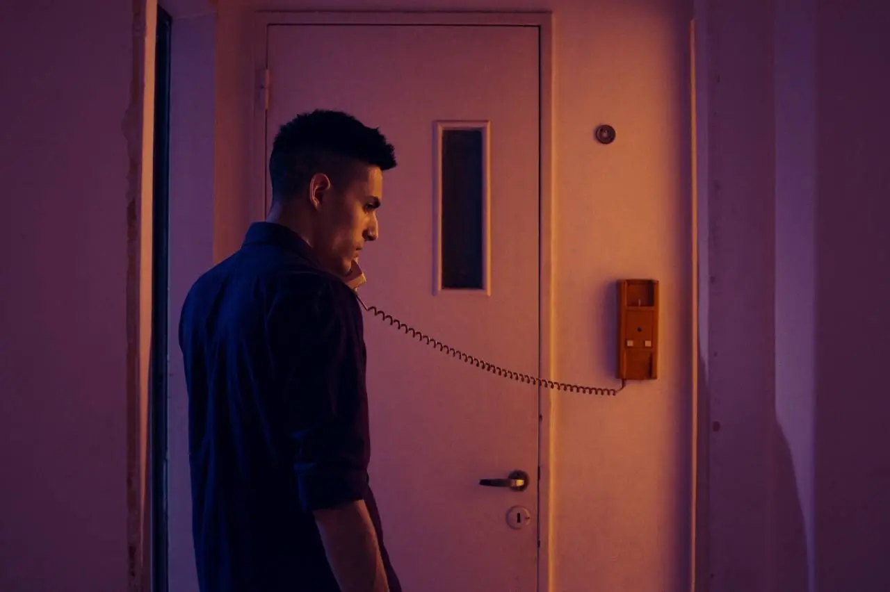 Side view of a man in a blue shirt making a phone call indoors in Buenos Aires.